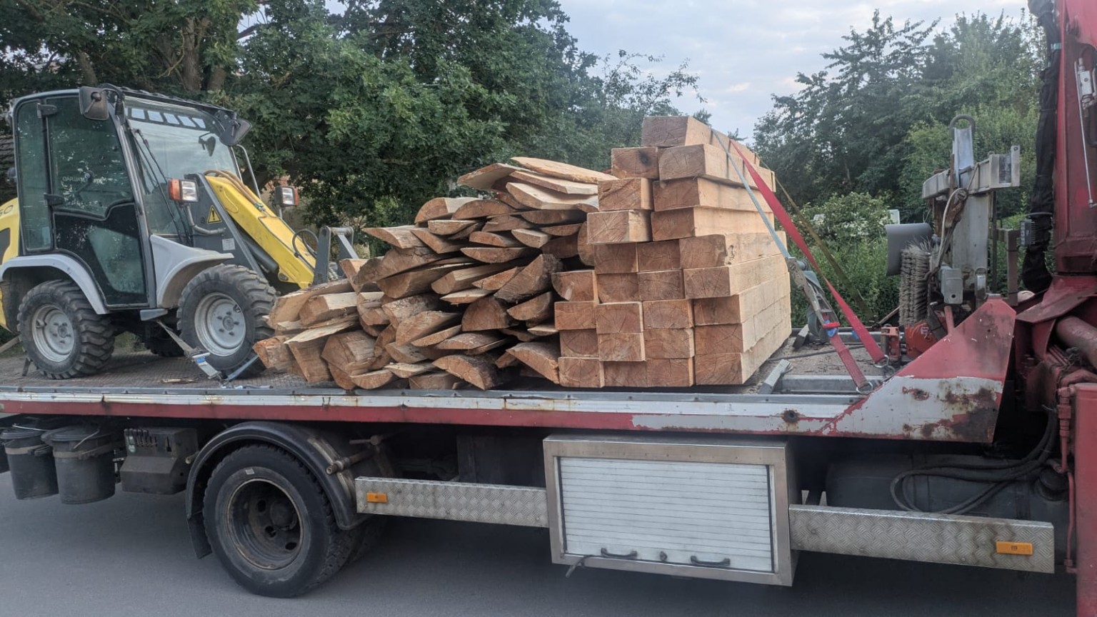 Bauholz und Radlader auf einem LKW